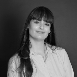 Portrait en noir et blanc d'une jeune femme souriante avec des bangs.